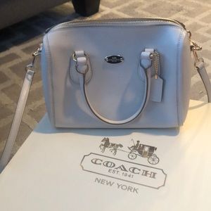 Cream colored coach purse .